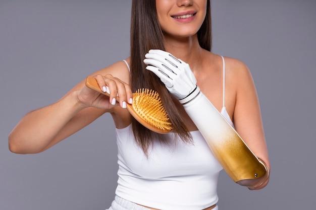 Smiling woman brushing her hair with a wooden hairbrush