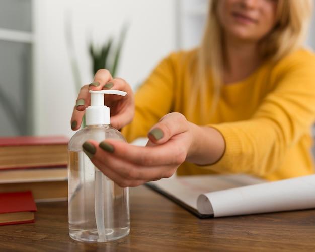 Woman using hand sanitizer at desk